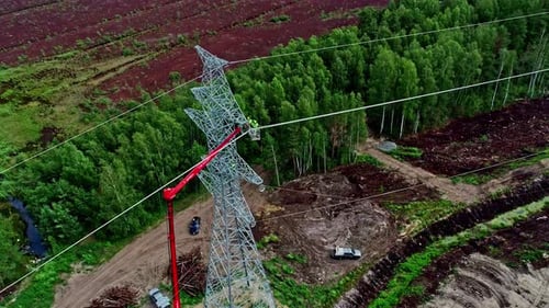 Aerial clip showing high voltage electric tower under maintenance