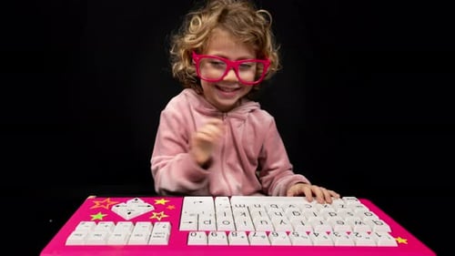 Happy Child with Pink Keyboard on Black Background
