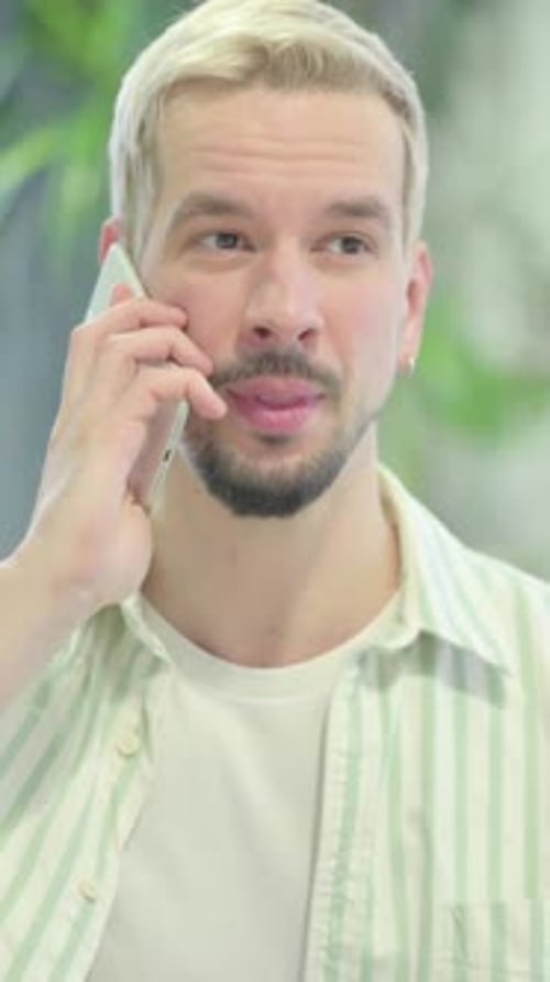 Moderner junger Mann, der am Telefon spricht