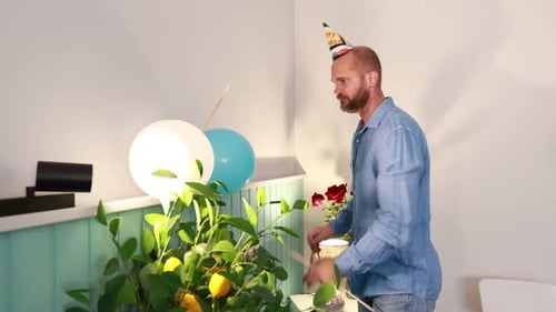 Man Decorating for Birthday Party with Balloons