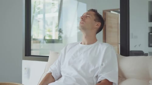 Fatigue Man Touching Face and Neck While Sitting on Couch Feeling Tired and Exhausted Fatigue