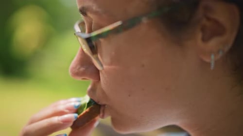 Woman Snacks Outside Food Enthusiast Savoring Meal Under Sunny Park Environment Relaxed Woman