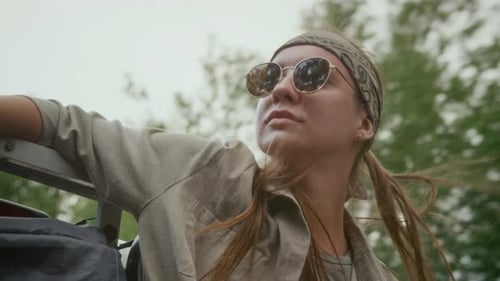 Relaxed Female Traveler Riding in Pickup Trunk in Countryside