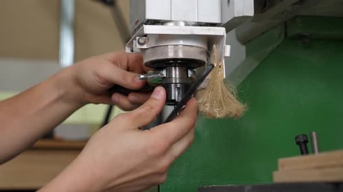 Worker Adjusts Milling Machine with Wrench