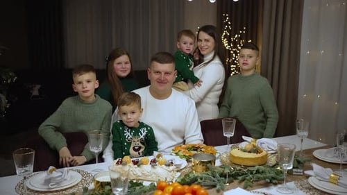 Smiling Family Posing at Christmas Dinner Table