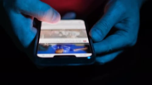 A Man's Finger Touches a Scrolling App on a Mobile Phone