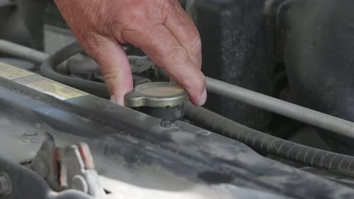 Hand Turns Radiator Cap On Car