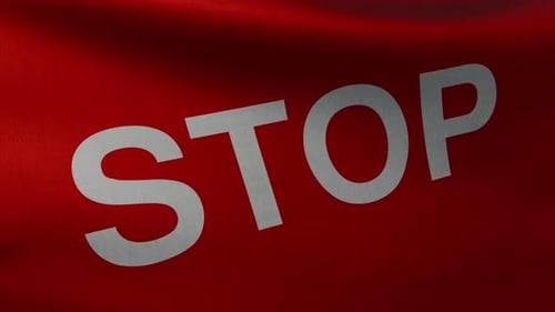 Closeup View of the Waving Flag with the Text STOP Shown at a Slight Angle