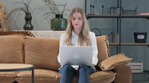 Woman With Laptop Reacts to Good News at Home