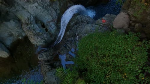 Aerial View of Waterfall Cascading into Pool