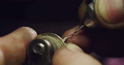 Close up of the hands of a goldsmith while he is working on a diamond ring. Concept: Style, fashio