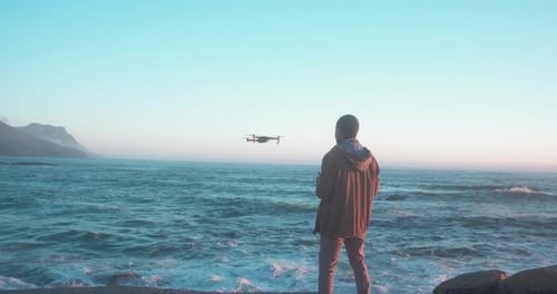 4k video footage of a young man flying a drone at the beach