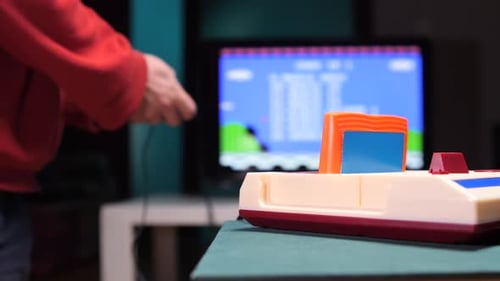 Person Playing a Retro Video Game Console