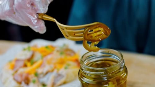 La mujer pone jalapeños marinados en la ensalada