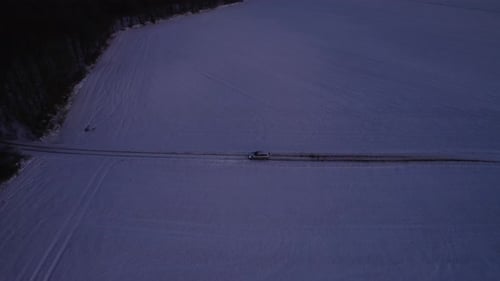 Drone View Of Car Breaking Down On Snowy Road In The Middle Of Empty Icy Field With Trees