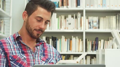 Focused Young Man Immersed in Reading a Book