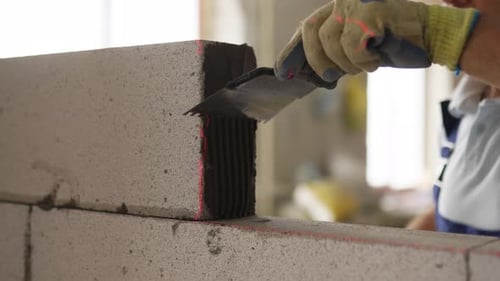 Bricklayer Applies Adhesive Glue on Autoclaved Aerated Concrete Blocks with Notched Trowel Brickwork