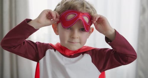 Blonde Haired Child Plays Dress Up with Mask