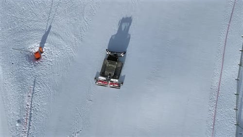 Pistenraupenmaschine, die auf einer Skipiste arbeitet, Luftaufnahme