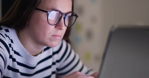 Young Adult Typing on Laptop at Night