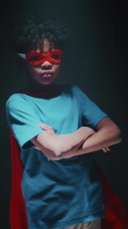 Little African American Kid in Superhero Costume Posing in Studio