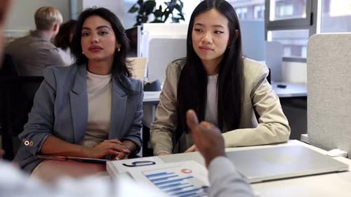 Two Women Working Together in Modern Urban Office