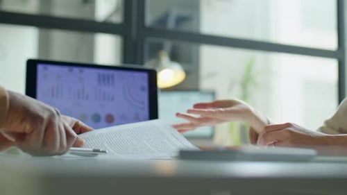Man and Woman Reviewing Contract in Modern Office