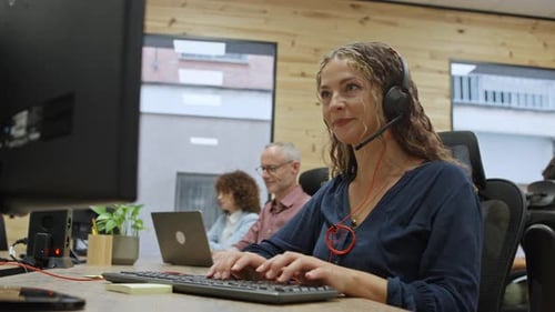 Customer Service Representative Working on Computer in Busy Office Business Concept