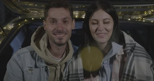 Portrait of Beautiful Couple Man and Woman Sitting in Car at Night Enjoying Road Trip
