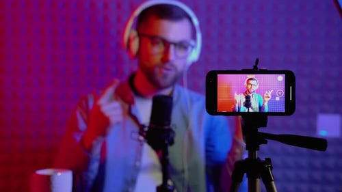 Blurred Man Talks on Podcast in Sound Booth