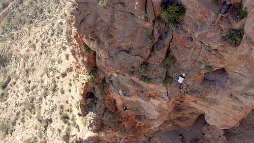 Via ferrata ascension by group of sportsmen drone aerial view of mountain and mountaineers climbing