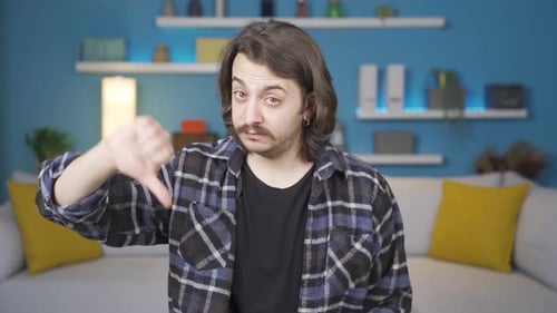 Man looking at camera making negative sign.