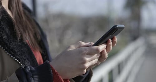 Close up of a young woman with her phone texting and browsing