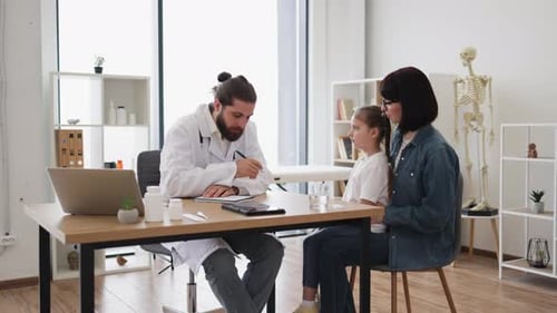 Caucasian Doctor Examining Young Girl with Mother in Clinic