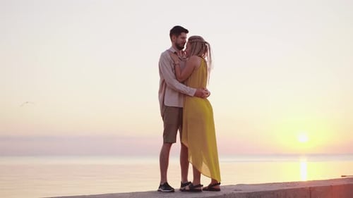 Loving Couple Embrace at Golden Sunrise by Ocean