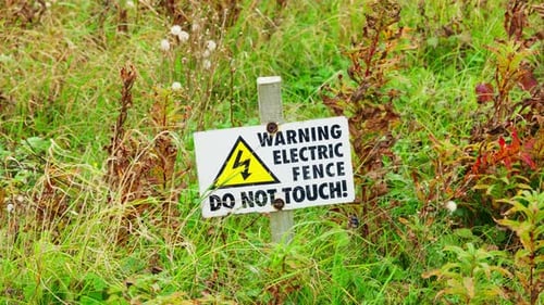 Warning sign placed in the ground to let people know the danger posed by the electric fence.