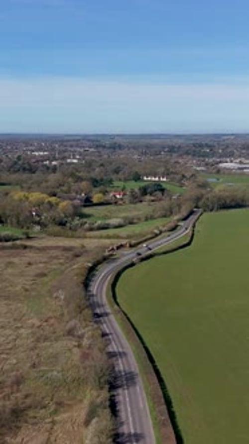 Vertical drone orbit over London Road, Hertford Heath, Hertfordshire countryside on bright day