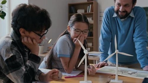 Teacher Explaining Wind Turbine Model to Students