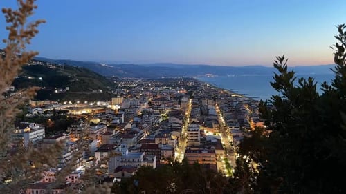 Night Timelapse Above an Active Coastal City in Sicily with Street Lights