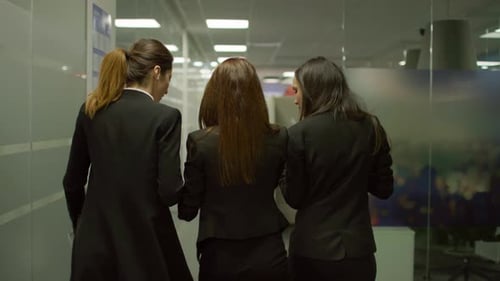 Kollegen, die in einem Bürokorridor spazieren gehen und diskutieren