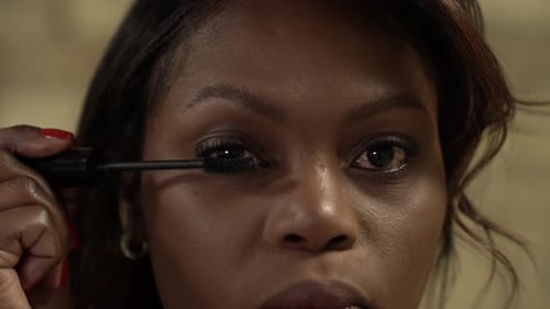 Close up as a black woman, applying eyelashes make up beauty industry.