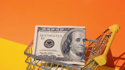 Handschiebbarer Spielzeug-Supermarktwagen mit 100-Dollar-Banknote im Einkaufswagen, gelb