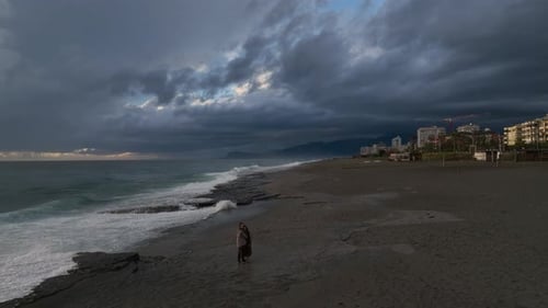 Couple Embracing on Dramatic Beach at Sunset