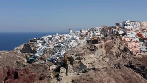 Coastal Village Of Oia At The Rugged Landscape In The Greek Island Of Santorini. aerial