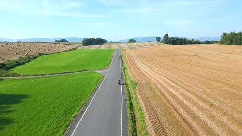 Motorcycle Riding a Road in Summer