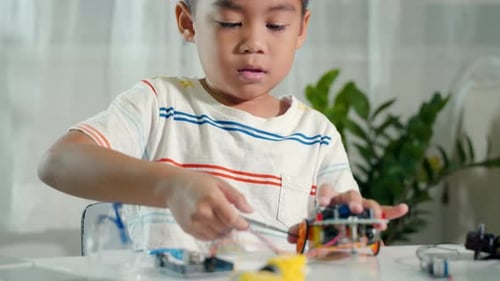 Little child trying assemble build wheel to car toy