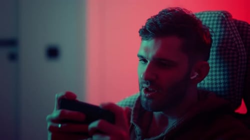 Excited Young Man Playing Video Game on Phone