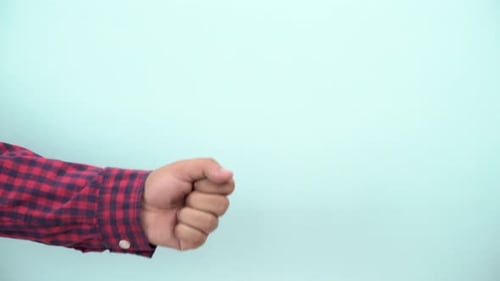 Arm Giving Thumbs Up on Light Blue Background