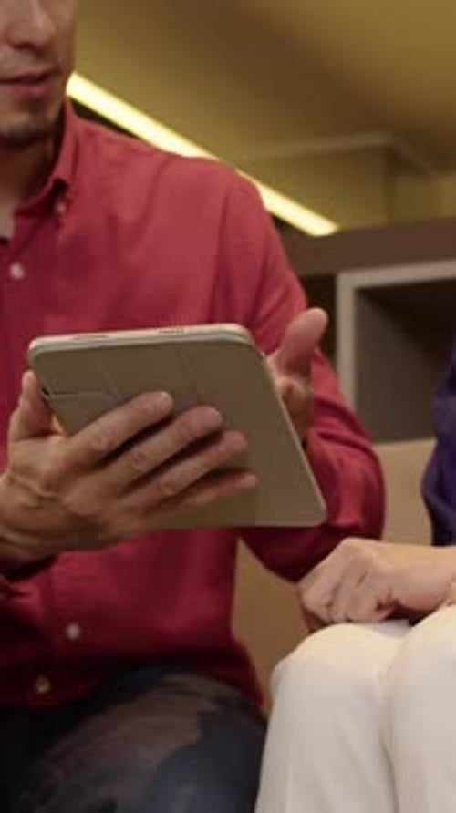 Man and Woman Using Tablet Device Indoors