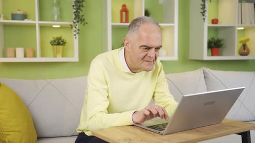 Senior Man Using Laptop Computer at Home